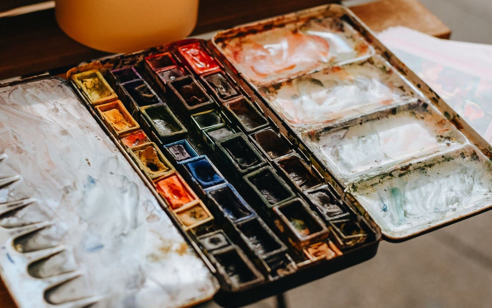 A small watercolour tin with the pans worn into hollows